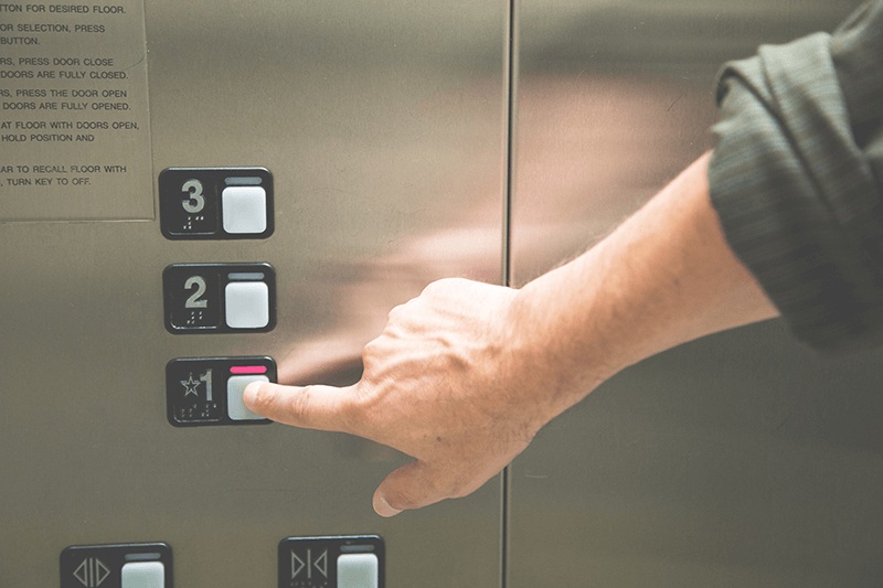 mano tocando el piso "1" de un ascensor